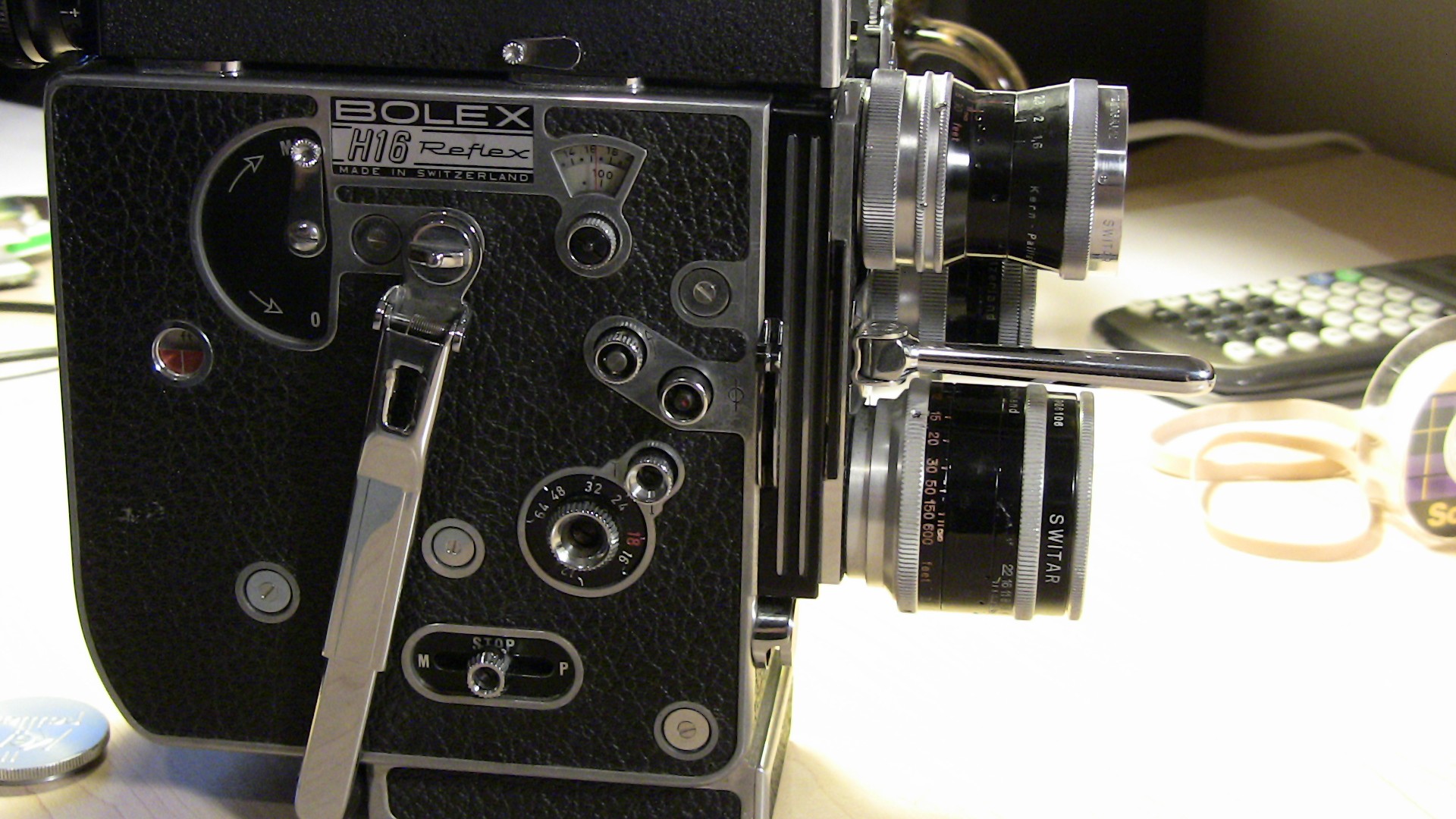 Image of vintage bolex h16 reflex camera, showcasing its classic design and intricate controls. made in switzerland, this historic film camera features textured black leatherette finish, dual lenses, and precise dials. ideal for film enthusiasts and collectors interested in retro filmmaking