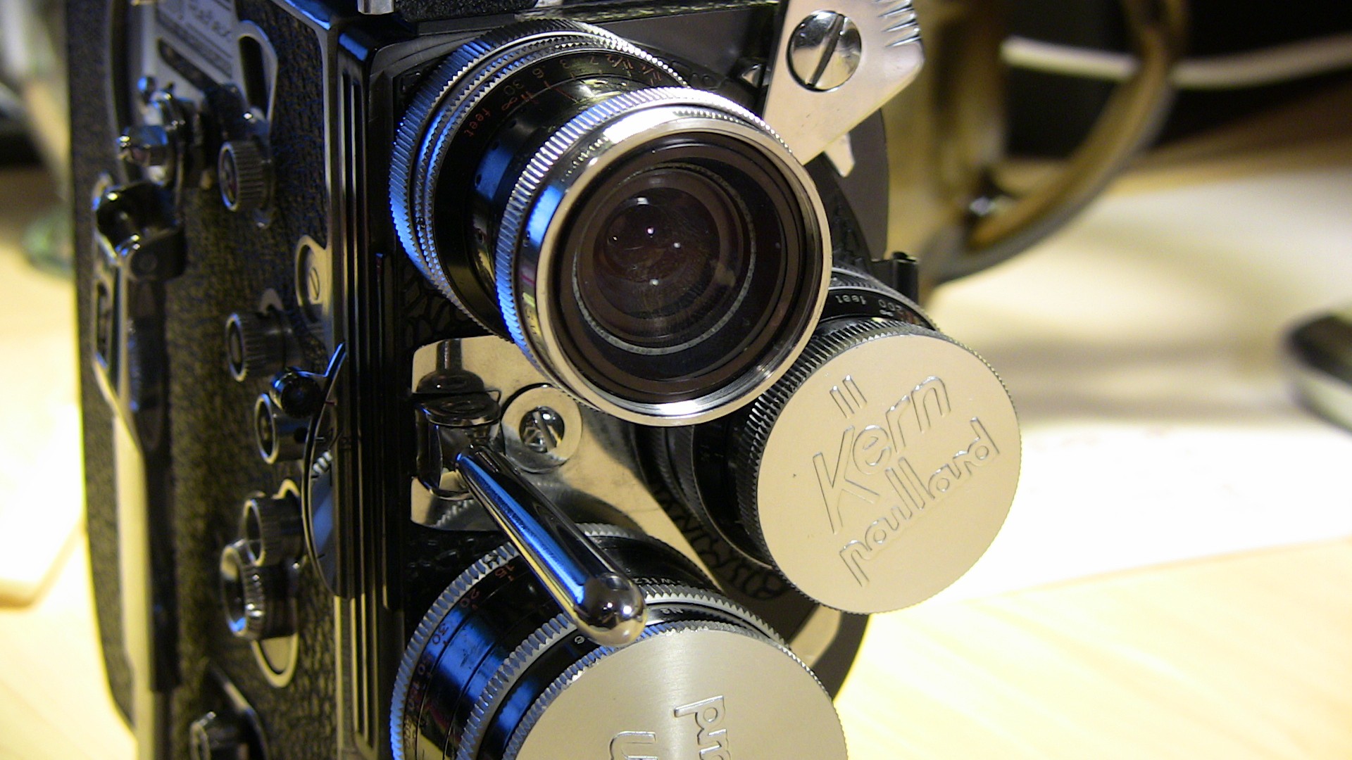 Image of close-up of a vintage bolex paillard 16mm film camera, showcasing its intricate dials and kern lens, ideal for retro filmmaking enthusiasts and vintage camera collectors. the classic design and manual controls highlight the craftsmanship of early cinematic equipment. perfect