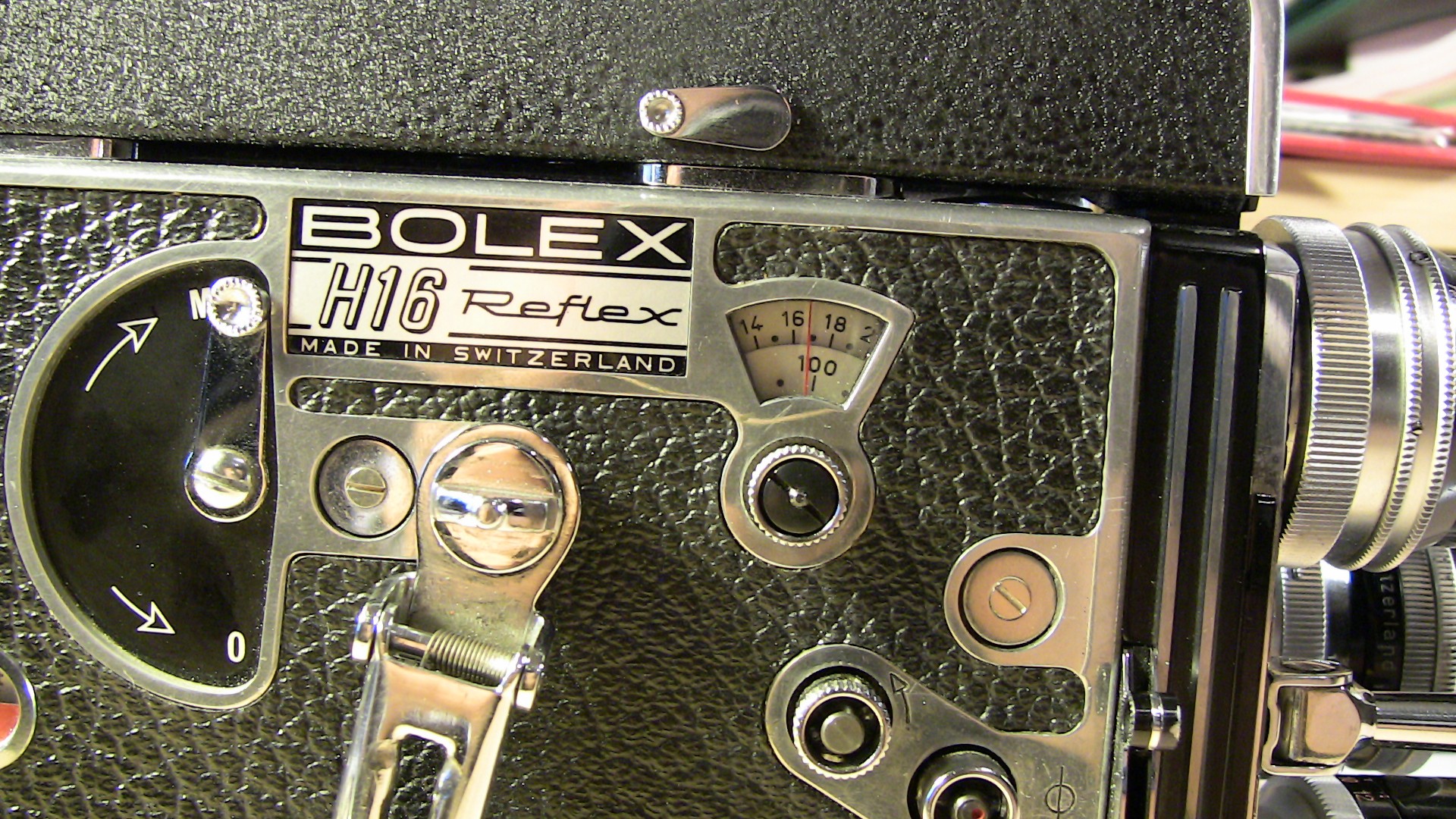 Image of close-up of a vintage bolex h16 reflex camera, showcasing intricate details of the swiss-made film camera's dials and mechanisms. the classic design is highlighted by its textured exterior and precise engineering, reflecting the craftsmanship and history of analog filmmaking equipment