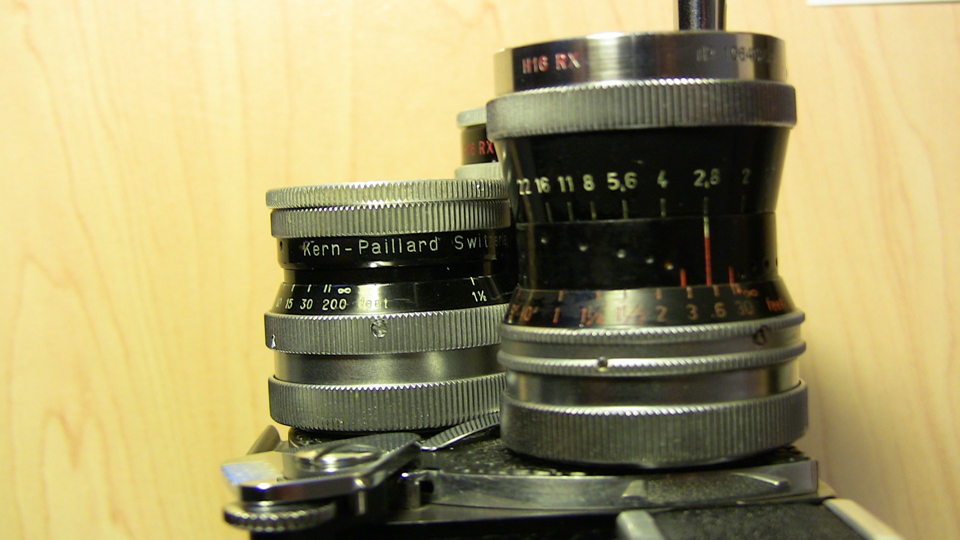Image of close-up view of vintage kern-paillard camera lenses showcasing precision engineering and classic design. the image highlights lens details, focusing on aperture settings and distance markings, perfect for photography enthusiasts and collectors interested in classic camera equipment.