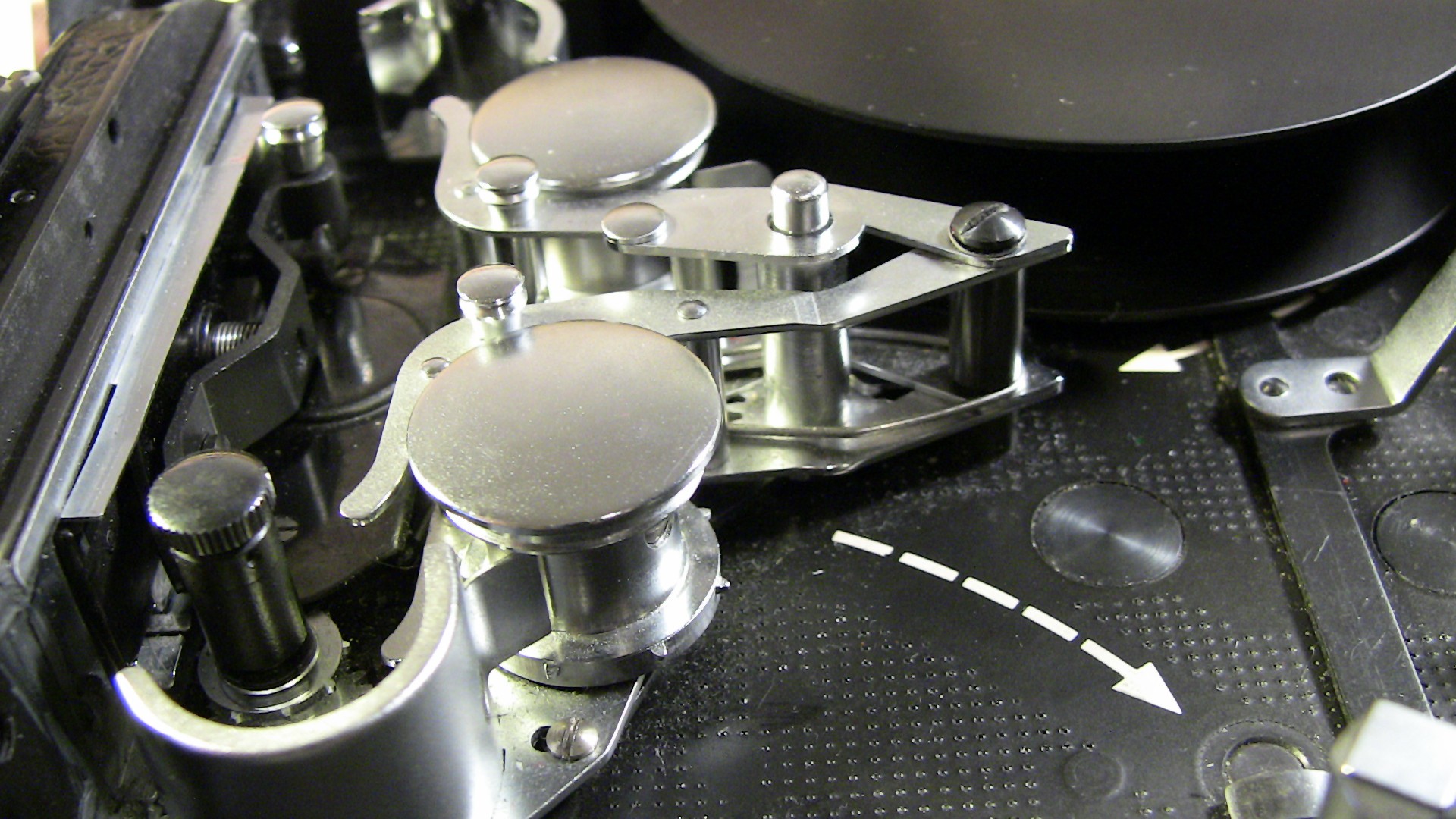 Image of the image showcases the intricate mechanical components of a vintage reel-to-reel tape machine, highlighting the metallic spindles and rollers responsible for guiding the tape. this close-up view emphasizes the precision engineering typical of analog audio equipment.