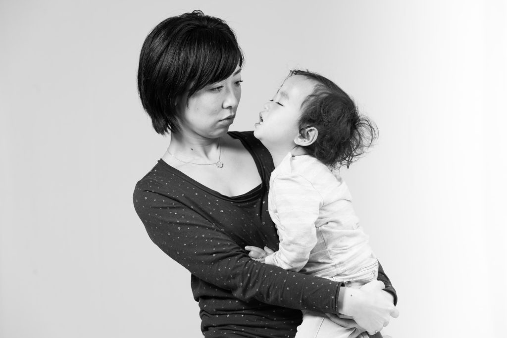 Image of a black and white photo capturing a tender moment between a mother and child. the mother holds her young child close, as they share a heartfelt interaction. family bond, love, and parenting emotions are vividly portrayed in this touching scene. perfect for themes related