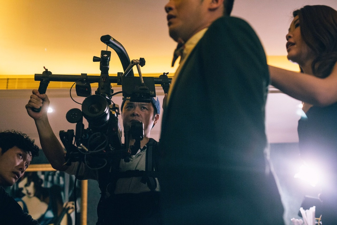 Image of film crew capturing an intense scene on set, featuring a cameraman using professional equipment to film actors in a dimly lit studio. this behind-the-scenes look reveals the dynamic process of movie production and filmmaking. keywords: film crew, cameraman, movie