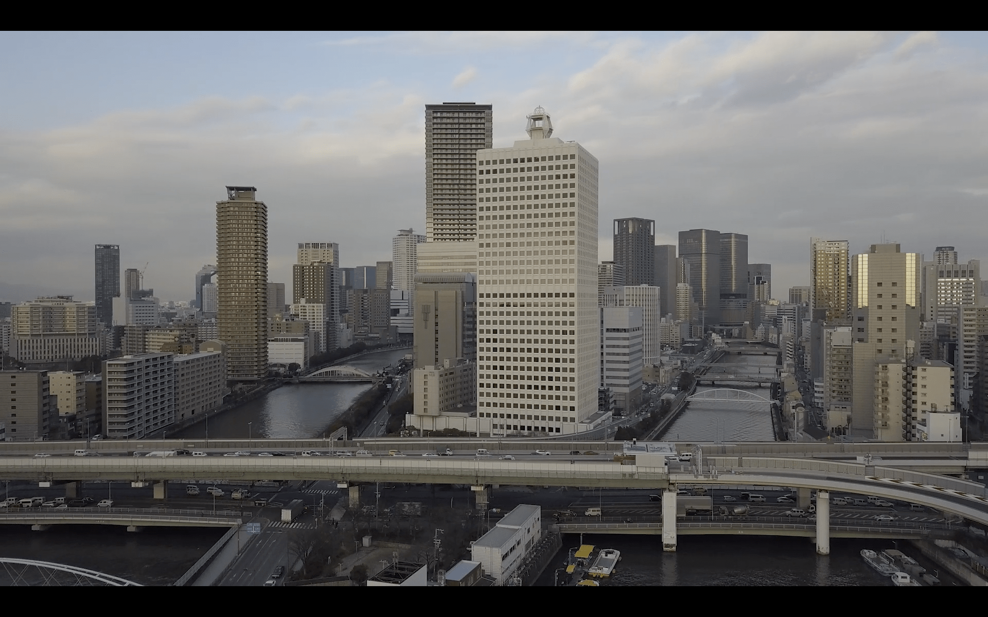 Image of aerial view of osaka's bustling cityscape featuring modern skyscrapers, urban architecture, and a network of highways and rivers. the skyline captures the dynamic essence of japan’s second-largest metropolitan area, highlighting its vibrant economic and cultural presence.