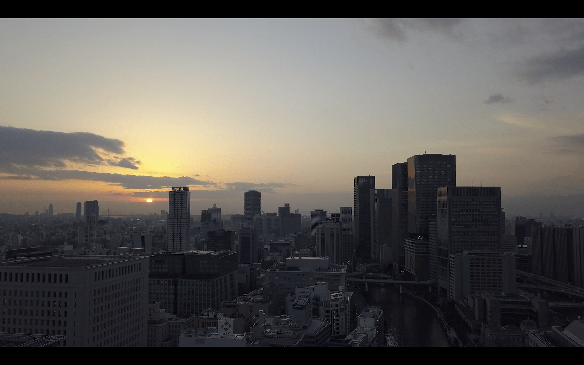 Image of a stunning sunset over osaka's urban skyline captures the city's modern architecture and vibrant atmosphere. this high-rise cityscape features towering buildings against a dramatic sky, highlighting the beauty of a metropolitan sunset in japan. perfect depiction of osaka's dynamic city life as day