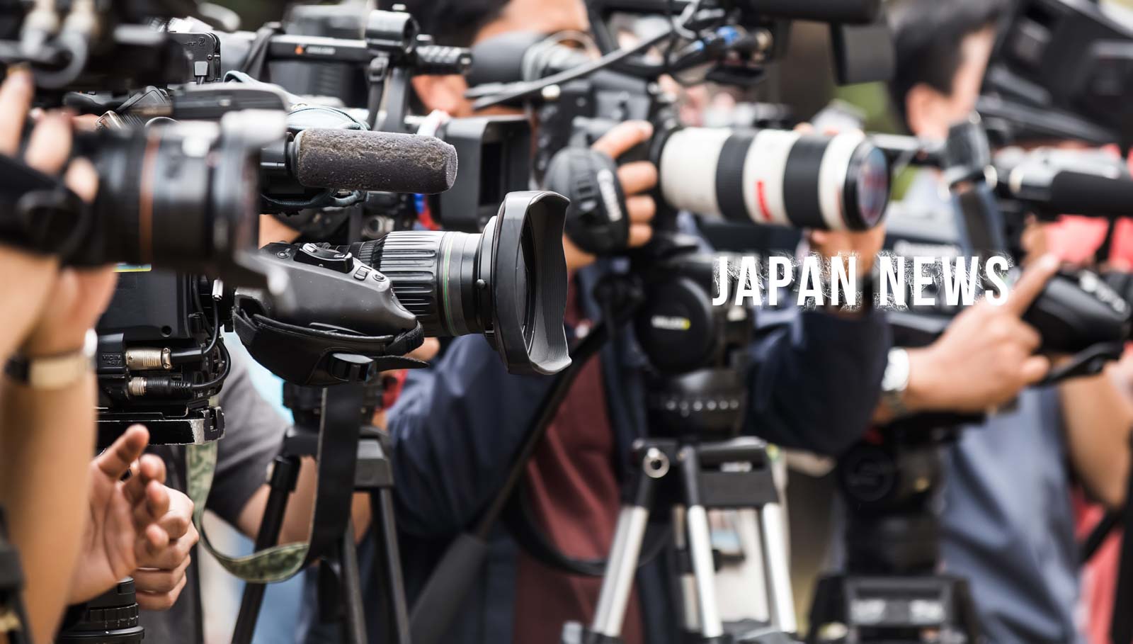 Image of close-up of a bustling media scene with cameras and microphones clustered together, capturing a live event in japan. the image highlights an active press environment, indicative of news coverage, with "japan news" prominently displayed. ideal for topics related to journalism, media