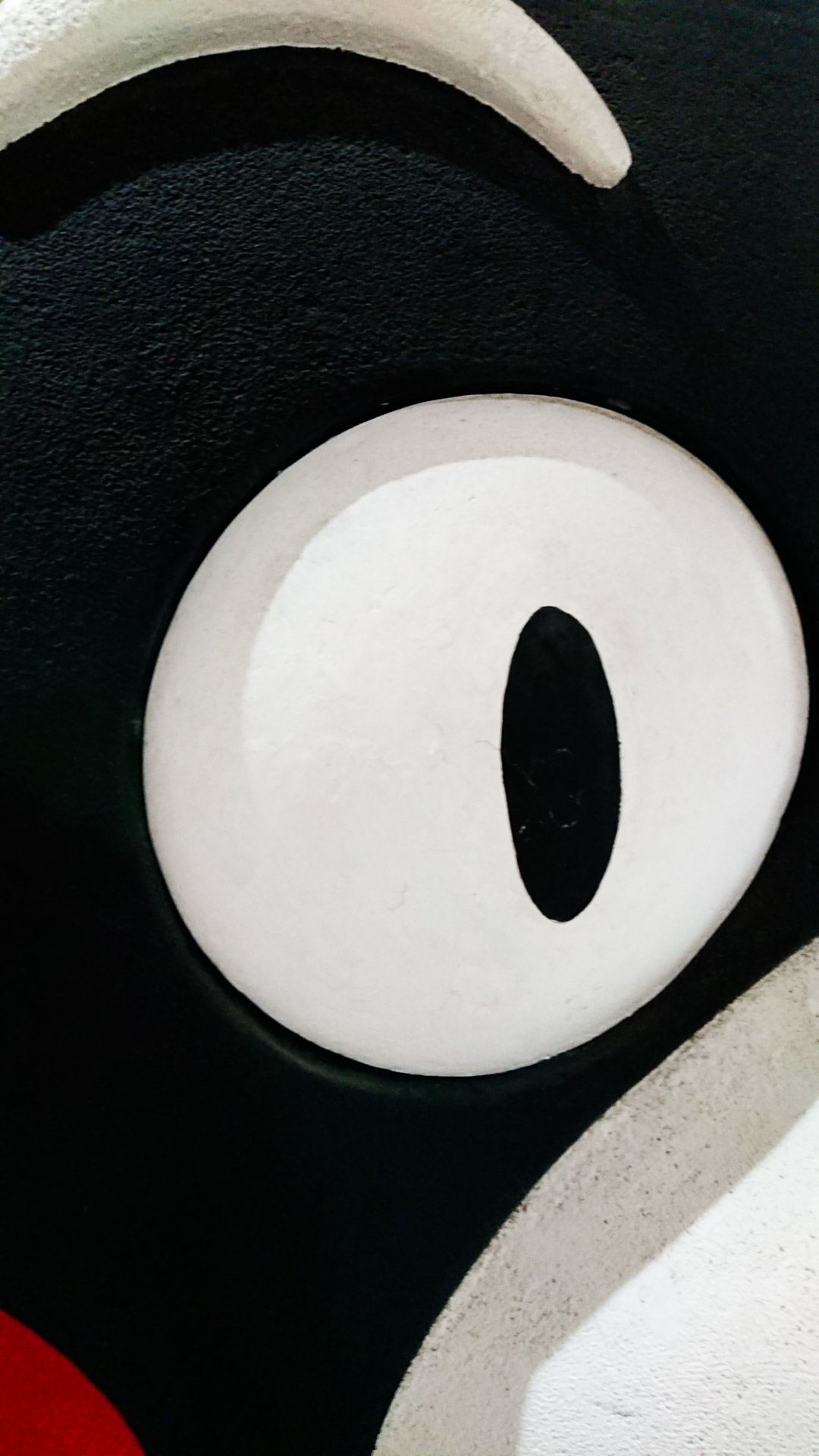 Image of close-up of a cartoon character's eye featuring bold, contrasting colors. the image highlights the exaggerated black outline and white interior, typical of animated figures. perfect for themes related to animation, art, and design.