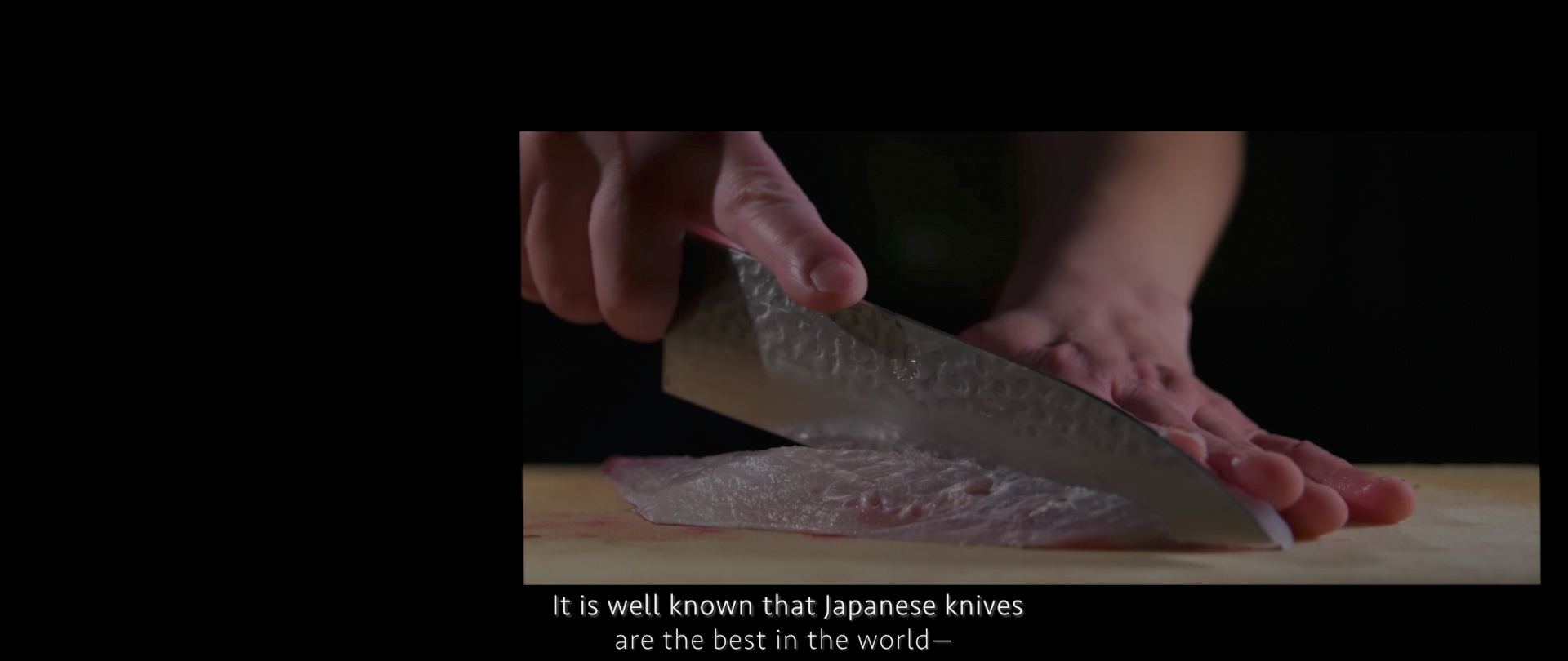 Image of a close-up image showcasing precise slicing techniques with a japanese knife, expertly cutting fish fillet on a wooden board. the scene highlights the renowned craftsmanship and sharpness of japanese cutlery, ideal for sushi preparation. text overlay emphasizes the global recognition of japanese
