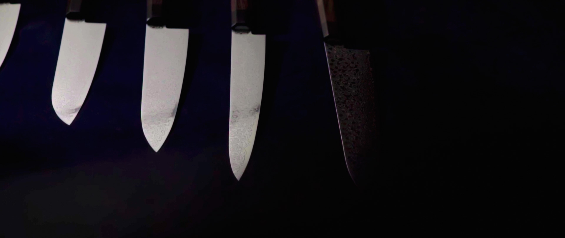 Image of this image features a set of sharp, high-quality kitchen knives with sleek blades, arranged against a dark background. the knives showcase precision and craftsmanship, ideal for culinary enthusiasts. keywords: kitchen knives, high-quality blades, culinary tools, knife set, professional