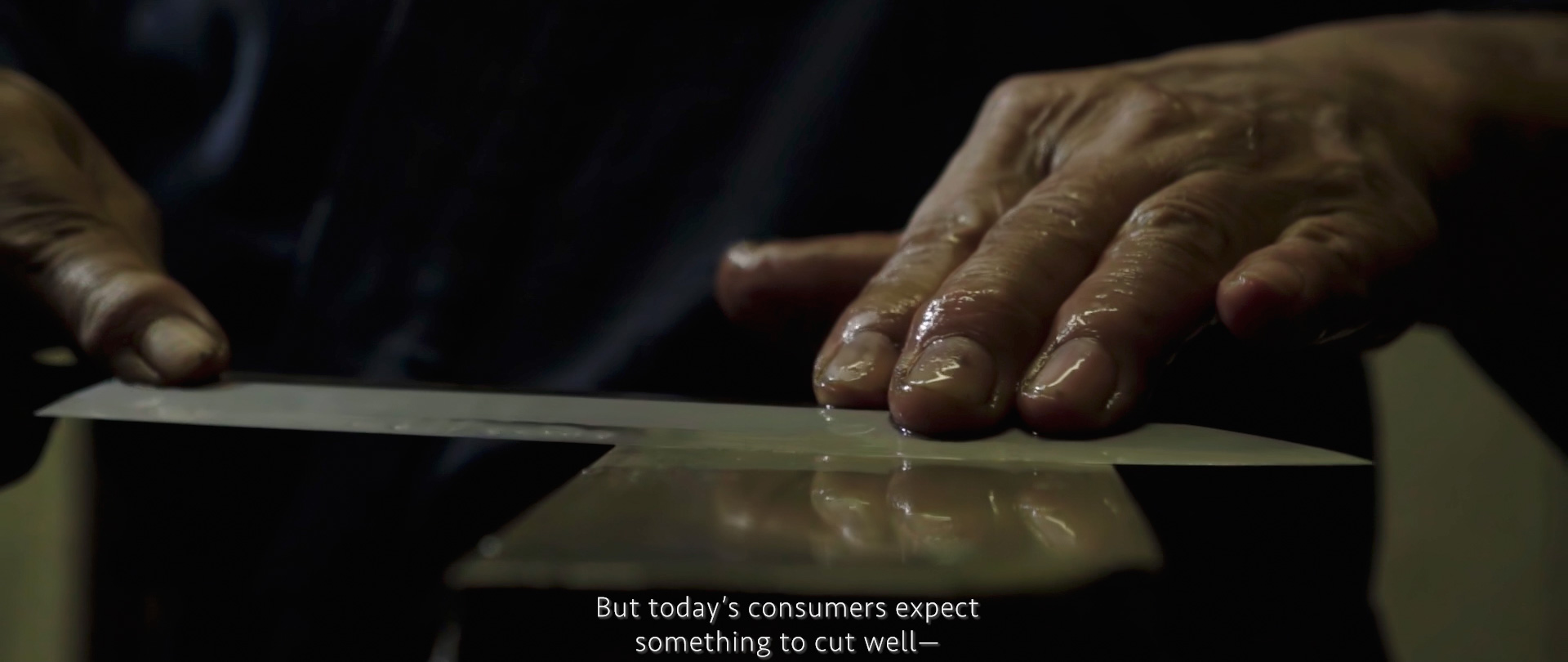 Image of close-up of a skilled craftsman's hand sharpening a knife blade, illustrating precision in traditional knife-making. the scene highlights the importance of quality tools for today's discerning consumers. perfect for keywords like "knife sharpening," "traditional craftsmanship," and "precision tools."