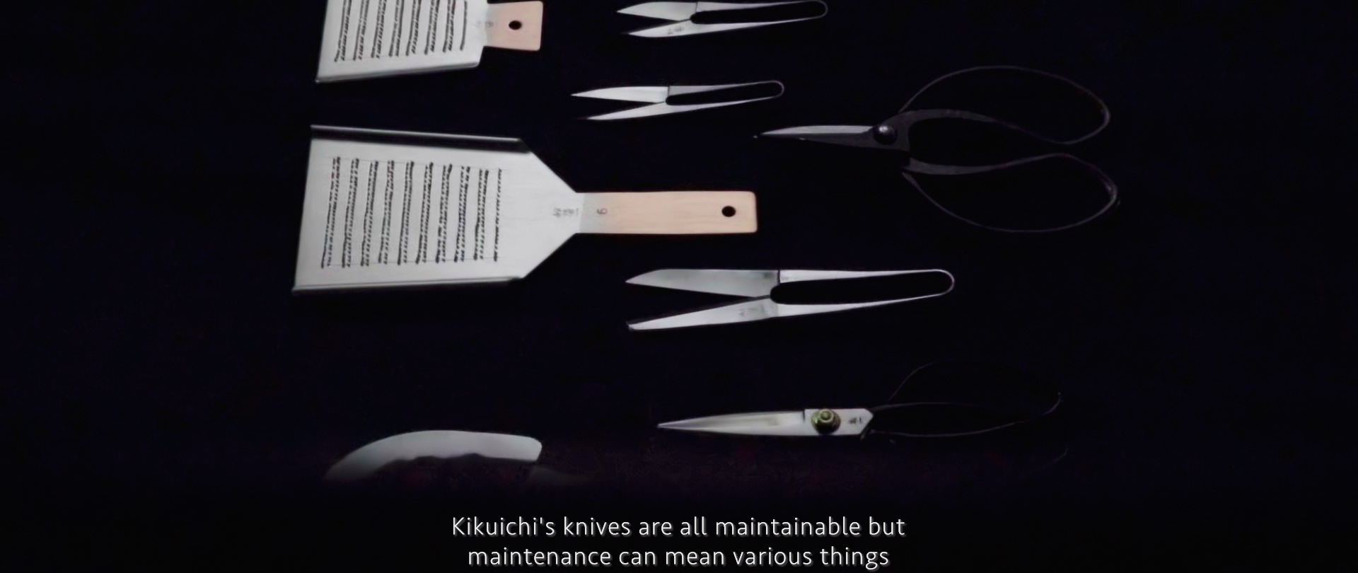 Image of the image showcases a collection of traditional japanese kitchen tools against a dark background. prominently featured are sleek knives and versatile scissors, reflecting the craftsmanship of kikuichi cutlery. the tools are positioned alongside two wooden-handled graters. the subtitle