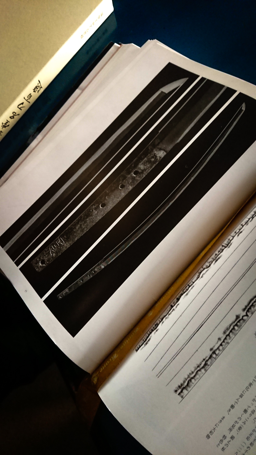 Image of this image features an open book displaying detailed illustrations and descriptions of a traditional japanese katana. the pages showcase the intricate design and craftsmanship of the sword, complemented by text and diagrams. this scene provides a compelling glimpse into japanese culture, martial arts, and