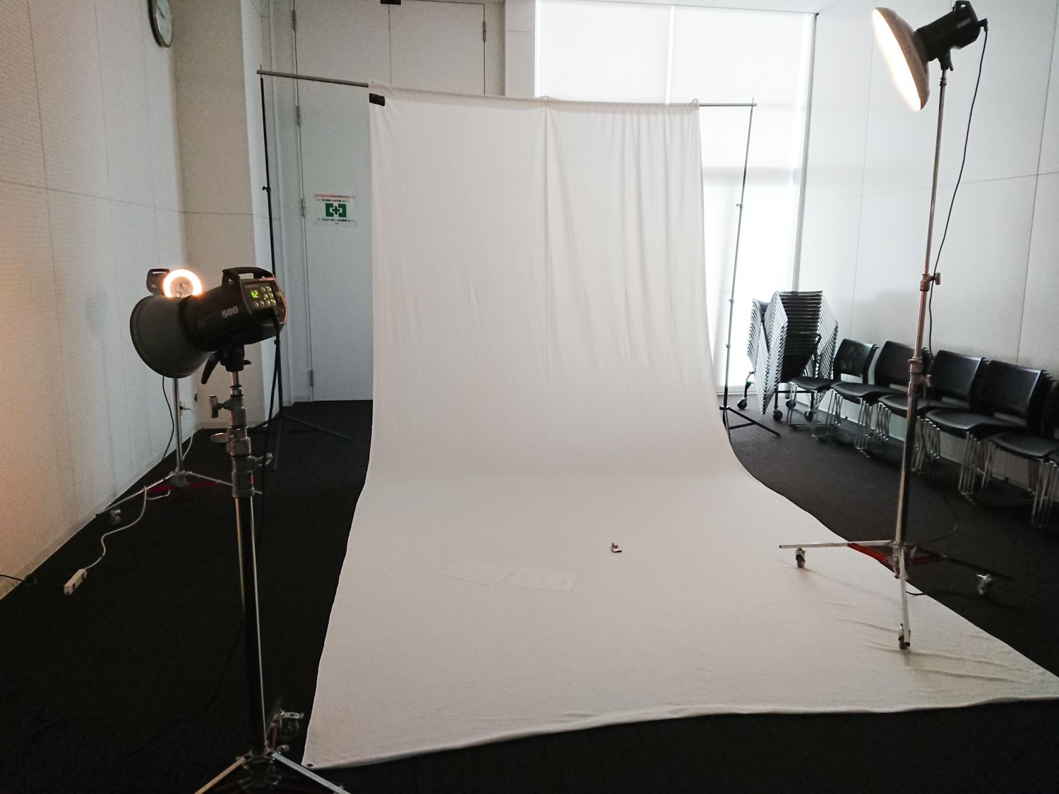 Image of photography studio setup with lighting equipment, featuring a white backdrop and softboxes in a professional indoor setting. ideal for portrait or product photography sessions.